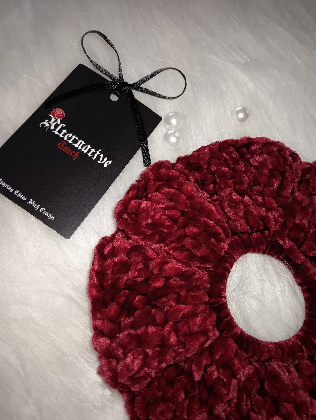Red velvet scrunchie with a tag on a light background