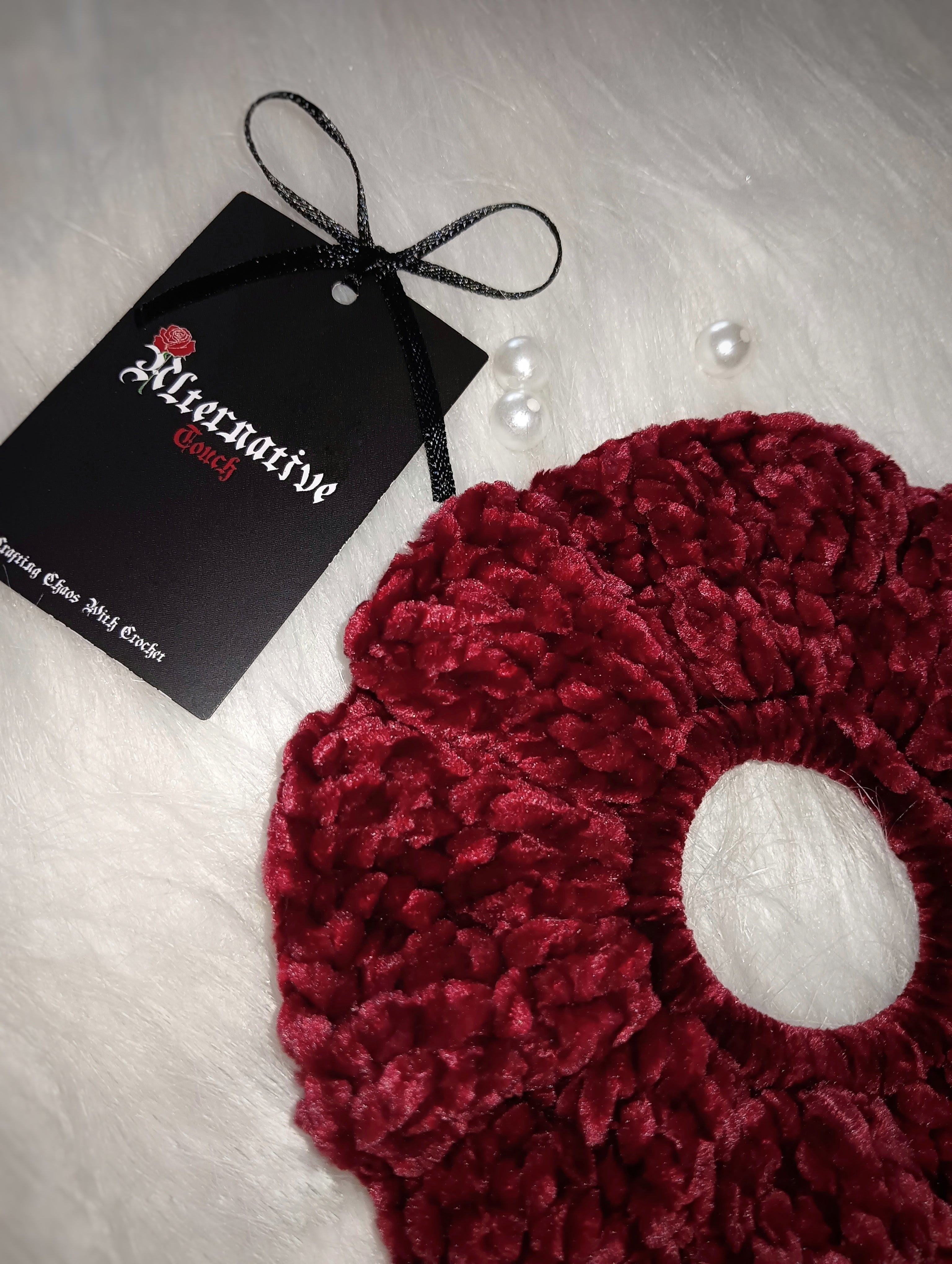 Red velvet scrunchie with a tag on a light background